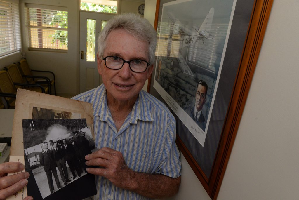 BERT HINKLER: Lex Rowland holding a photograph showing Bert Hinkler (centre) and his mechanic (far right). Photo: Mike Knott / NewsMail BERT HINKLER: Lex Rowland holding a photograph showing Bert Hinkler (centre) and his mechanic (far right). Photo: Mike Knott / NewsMail
