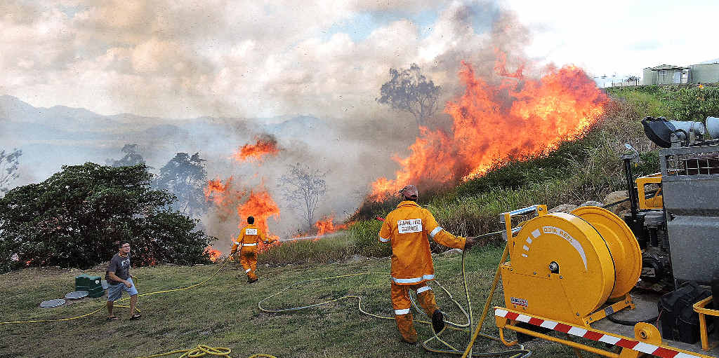 Firefighters and home owners battle to fight flames roaring up the hillside to the lawns of houses on top of a hill near The Leap, 21m north of Mackay, yesterday. Firefighters and home owners battle to fight flames roaring up the hillside to the lawns of houses on top of a hill near The Leap, 21m north of Mackay, yesterday.