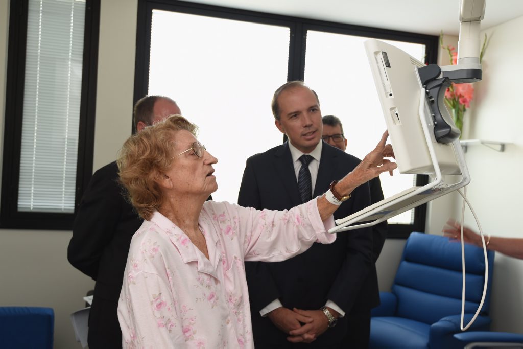 St Stephens Hospital patient Beverly Kersnovske shows Federal Health Minister Peter Dutton some of the functions on the Patient Entertainment System in her room. St Stephens Hospital patient Beverly Kersnovske shows Federal Health Minister Peter Dutton some of the functions on the Patient Entertainment System in her room.
