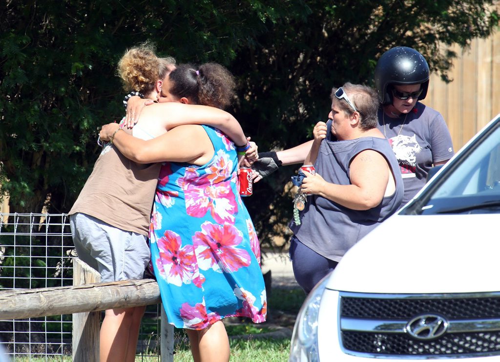 Distraught locals embrace at the scene after eight children were found stabbed to death at a house in Manoora near Cairns, Friday, Dec. 19, 2014. Eight children, aged between 18 months and 15 years, have been found dead in a house in Cairns, with a woman believed to be their mother in hospital with stab wounds. (AAP Image/Romy Bullerjahn) NO ARCHIVING Distraught locals embrace at the scene after eight children were found stabbed to death at a house in Manoora near Cairns, Friday, Dec. 19, 2014. Eight children, aged between 18 months and 15 years, have been found dead in a house in Cairns, with a woman believed to be their mother in hospital with stab wounds. (AAP Image/Romy Bullerjahn) NO ARCHIVING