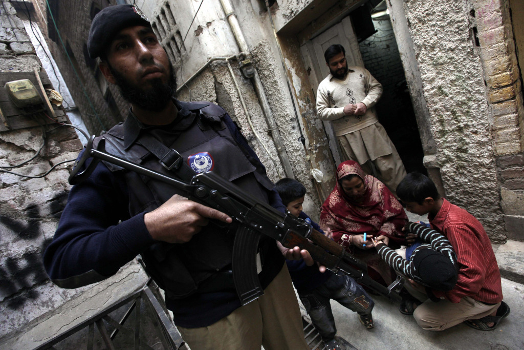 A member of the Pakistani security services stands guard while a health worker administers a polio vaccine to a child, in Peshawar, Pakistan, 20 December 2014. More than 65 polio worker and security personnel have been killed by the militants, according to Health Minister Saira Afzal Tarar. Extremists claim the vaccination campaign is a cover for a plot to sterilize Muslims. A member of the Pakistani security services stands guard while a health worker administers a polio vaccine to a child, in Peshawar, Pakistan, 20 December 2014. More than 65 polio worker and security personnel have been killed by the militants, according to Health Minister Saira Afzal Tarar. Extremists claim the vaccination campaign is a cover for a plot to sterilize Muslims.