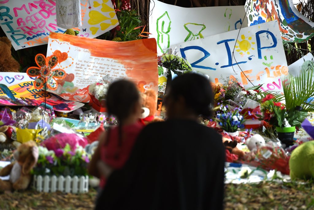 Mourners attend a floral tribute near a house in which eight children were stabbed to death in the Cairns suburb of Manoora, Sunday, Dec. 21, 2014. Their mother, who was taken hospital with stab wounds, has been charged with their murders. Mourners attend a floral tribute near a house in which eight children were stabbed to death in the Cairns suburb of Manoora, Sunday, Dec. 21, 2014. Their mother, who was taken hospital with stab wounds, has been charged with their murders.