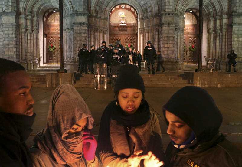 St. Louis Police officers guard the entrance to the Cathedral Basilica before Midnight Mass as protesters held a candlelight vigil on Wednesday, Dec. 24, 2014, in St. Louis. The mayor of the St. Louis suburb of Berkeley urged calm Wednesday after a white police officer killed black 18-year-old Antonio Martin who police said pointed a gun at him. St. Louis Police officers guard the entrance to the Cathedral Basilica before Midnight Mass as protesters held a candlelight vigil on Wednesday, Dec. 24, 2014, in St. Louis. The mayor of the St. Louis suburb of Berkeley urged calm Wednesday after a white police officer killed black 18-year-old Antonio Martin who police said pointed a gun at him.