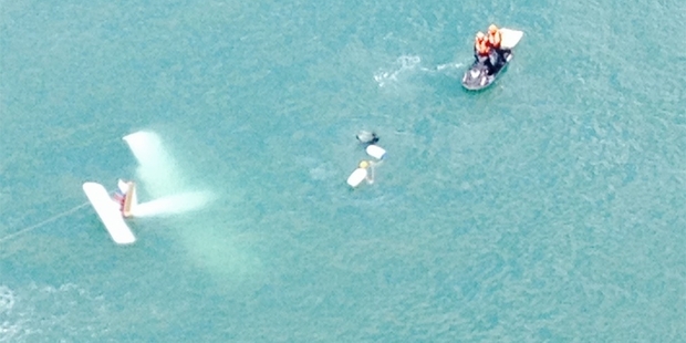 Coastguard, surfers and police secure the light aircraft which crashed into Raglan Harbour yesterday. Coastguard, surfers and police secure the light aircraft which crashed into Raglan Harbour yesterday.