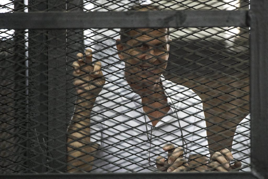 Al-Jazeera channel's Australian journalist Peter Greste stands inside the defendants cage during his trial for allegedly supporting the Muslim Brotherhood on June 1, 2014 at the police institute near Cairo's Tora prison. The high-profile case that sparked a global outcry over muzzling of the press is seen as a test of the military-installed government's tolerance of independent media, with activists fearing a return to autocracy three years after the Arab Spring uprising that toppled Hosni Mubarak. AFP PHOTO / KHALED DESOUKI Al-Jazeera channel's Australian journalist Peter Greste stands inside the defendants cage during his trial for allegedly supporting the Muslim Brotherhood on June 1, 2014 at the police institute near Cairo's Tora prison. The high-profile case that sparked a global outcry over muzzling of the press is seen as a test of the military-installed government's tolerance of independent media, with activists fearing a return to autocracy three years after the Arab Spring uprising that toppled Hosni Mubarak. AFP PHOTO / KHALED DESOUKI