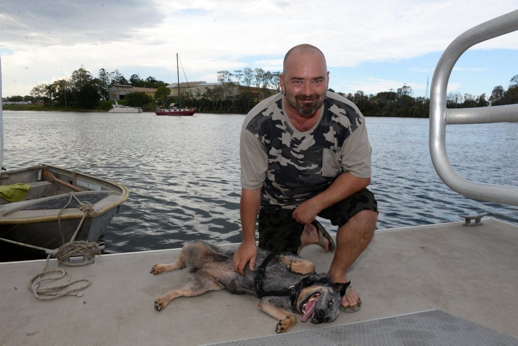 BEST FRIENDS: Mark Huggy Hughes and his dog Shiela with their yacht Vardos moored in the background on the Burnett River. Photo: Mike Knott / NewsMail BEST FRIENDS: Mark Huggy Hughes and his dog Shiela with their yacht Vardos moored in the background on the Burnett River. Photo: Mike Knott / NewsMail