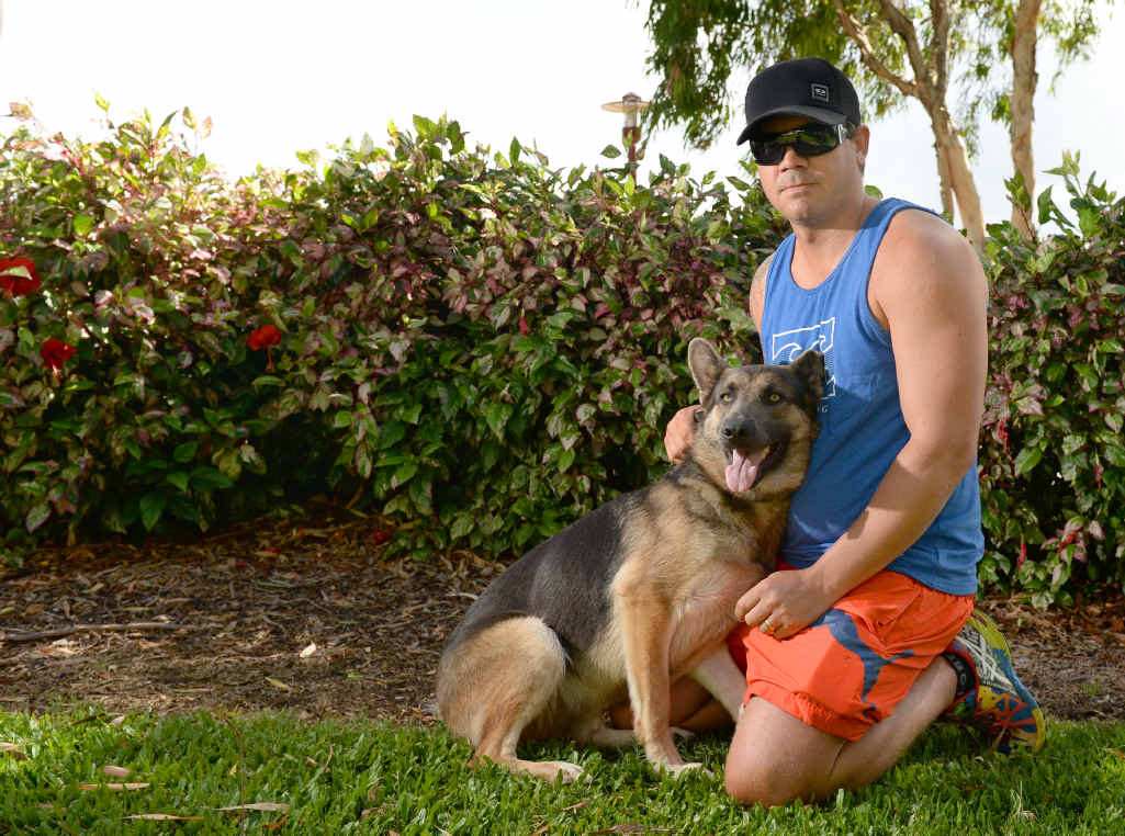 LOYAL COMPANION: Julian Lawton with Mishka who bit a bank robber as he tried to steal a bicycle over the back fence on Thursday. LOYAL COMPANION: Julian Lawton with Mishka who bit a bank robber as he tried to steal a bicycle over the back fence on Thursday.