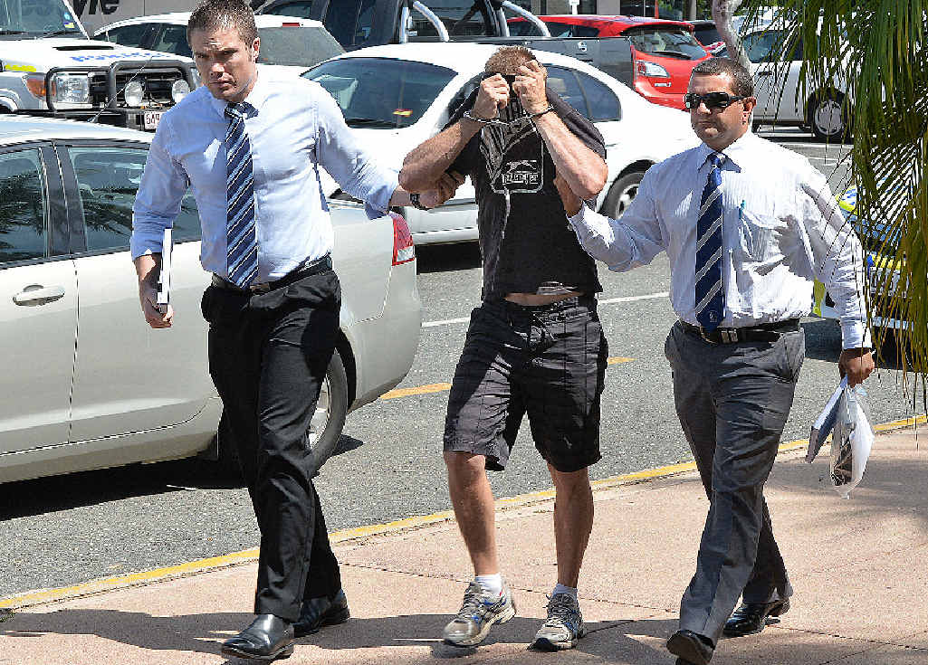 Detectives lead the accused man into the Mackay police station. Detectives lead the accused man into the Mackay police station.