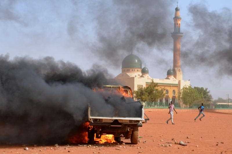 People run past a police truck Aset on fire by protesters during a demonstration against French weekly Charlie Hebdo's publication of a cartoon of the Prophet Mohammed in front of the grand mosque in Niamey on January 17, 2015. People run past a police truck Aset on fire by protesters during a demonstration against French weekly Charlie Hebdo's publication of a cartoon of the Prophet Mohammed in front of the grand mosque in Niamey on January 17, 2015.