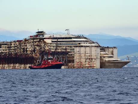 The refloated wreck of the Costa Concordia cruise ship as it was dragged to the harbor of Pra di Voltri near Genoa The refloated wreck of the Costa Concordia cruise ship as it was dragged to the harbor of Pra di Voltri near Genoa