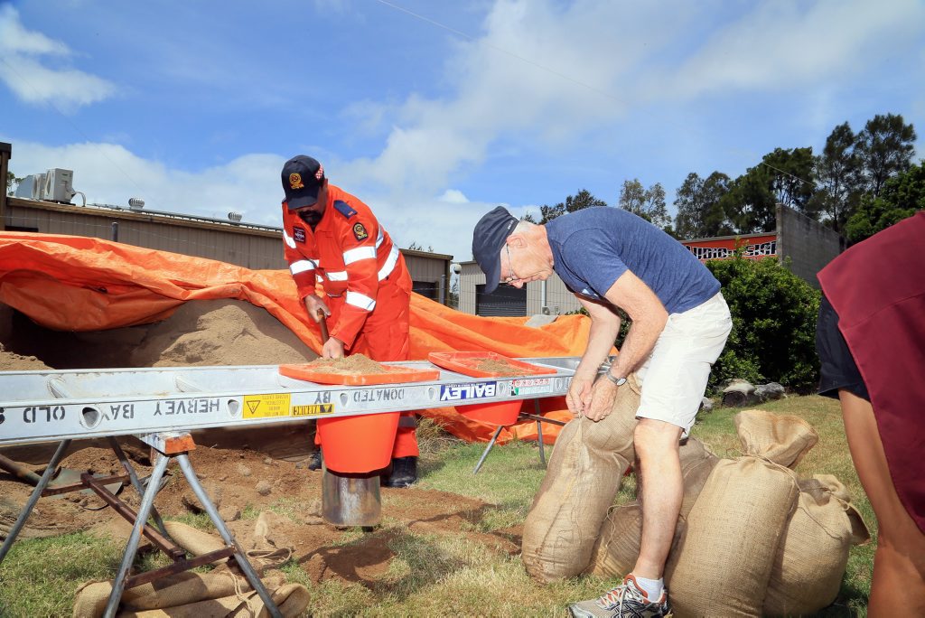 SES member Corey Waynwright filling sandbags for concerned Esplanade shop owner Ashleigh Manley. SES member Corey Waynwright filling sandbags for concerned Esplanade shop owner Ashleigh Manley.
