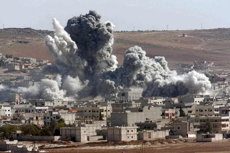 Thick smoke from an airstrike by the US-led coalition rises in Kobani, Syria, as seen from a hilltop on the outskirts of Suruc, at the Turkey-Syria border. Thick smoke from an airstrike by the US-led coalition rises in Kobani, Syria, as seen from a hilltop on the outskirts of Suruc, at the Turkey-Syria border.