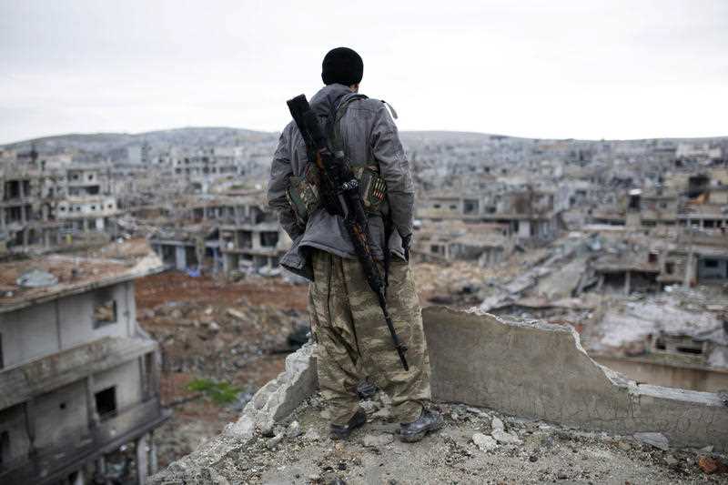 A Syrian Kurdish sniper looks at the rubble in the Syrian city of Ain al-Arab, also known as Kobani. A Syrian Kurdish sniper looks at the rubble in the Syrian city of Ain al-Arab, also known as Kobani.