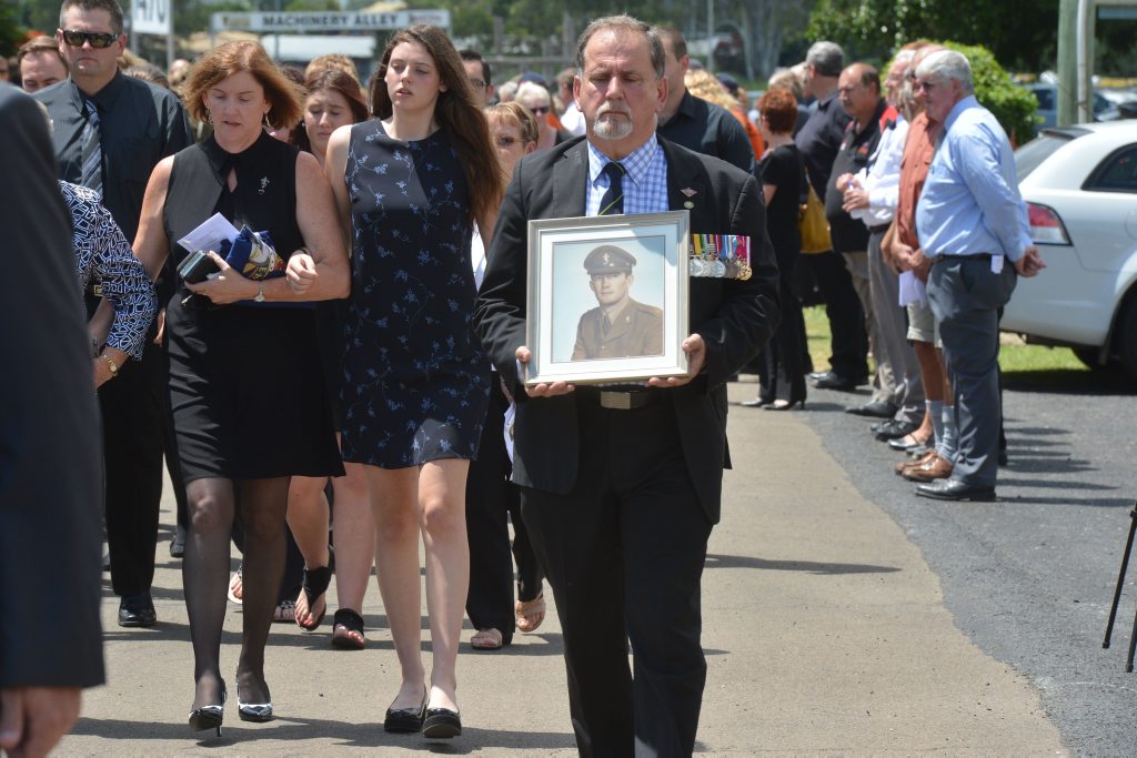 PHOTO: A funeral goer carries a picture of Ron Dyne in his military days. PHOTO: A funeral goer carries a picture of Ron Dyne in his military days.