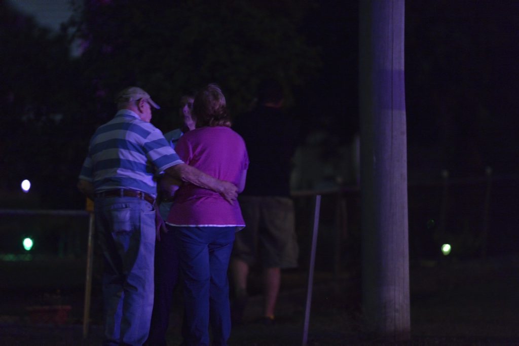 People gather outside the home where three people were shot dead. People gather outside the home where three people were shot dead.