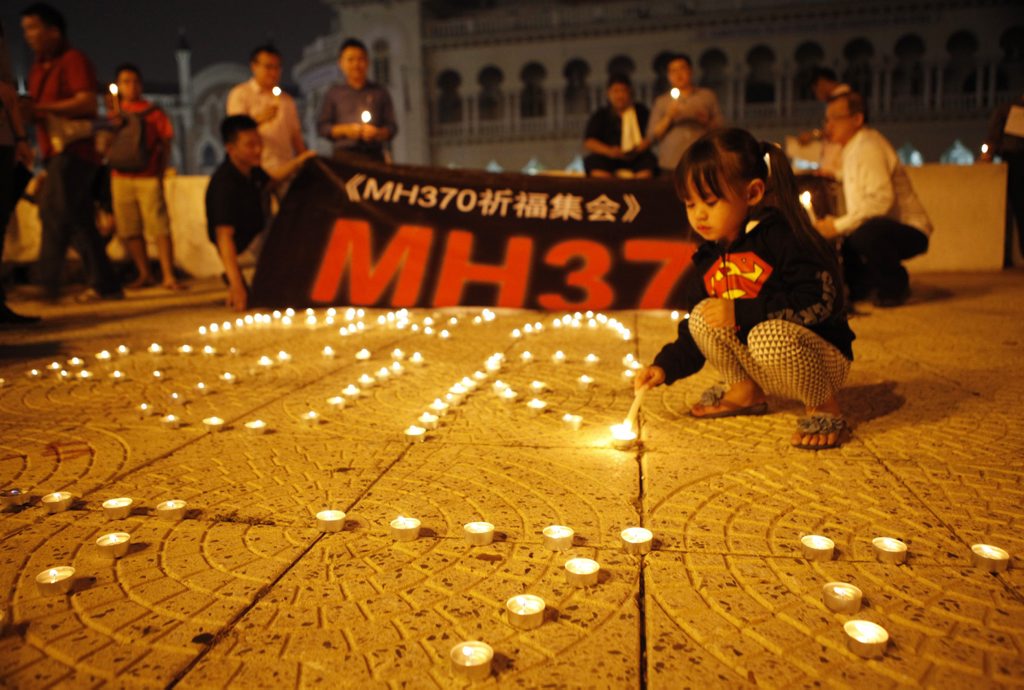 People light up candles and hold a banner during a candlelight vigil for the passengers aboard the missing Boeing 777-200 plane of Malaysia Airlines Flight MH370 in Kuala Lumpur, Malaysia, 10 March 2014. People light up candles and hold a banner during a candlelight vigil for the passengers aboard the missing Boeing 777-200 plane of Malaysia Airlines Flight MH370 in Kuala Lumpur, Malaysia, 10 March 2014.