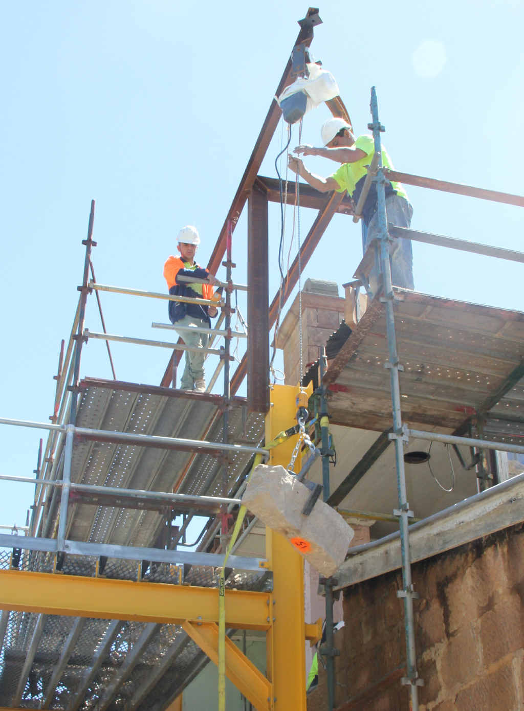 Workers deconstructing the western wall, stone by stone.