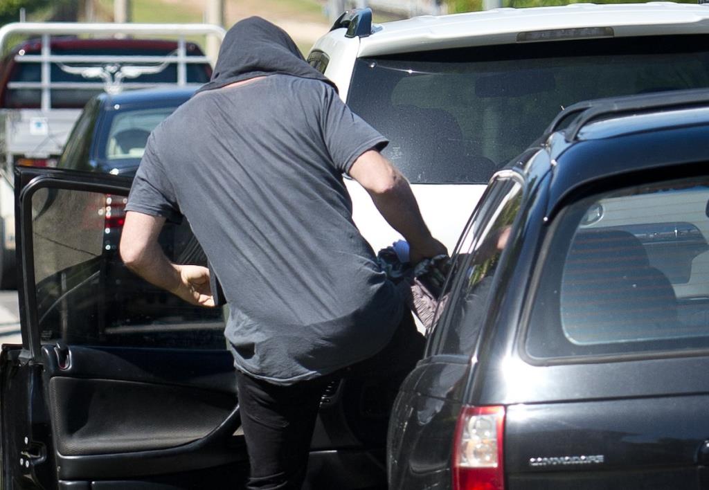 Steve Parnell sneaks past pedestrians with his head covered as he leaves Gladstone Magistrates Court. Steve Parnell sneaks past pedestrians with his head covered as he leaves Gladstone Magistrates Court.