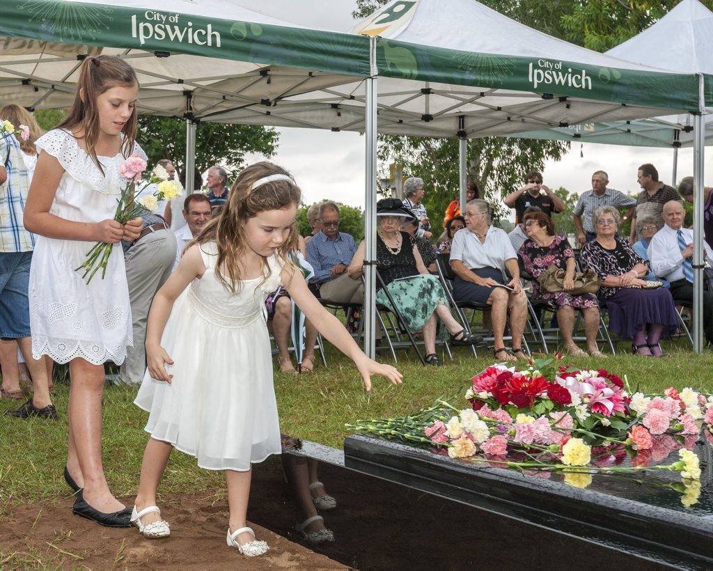 SOLEMN CEREMONY: Rose Robinson and Sophie Griffin lay flowers at the Babies of Walloon grave dedication. SOLEMN CEREMONY: Rose Robinson and Sophie Griffin lay flowers at the Babies of Walloon grave dedication.