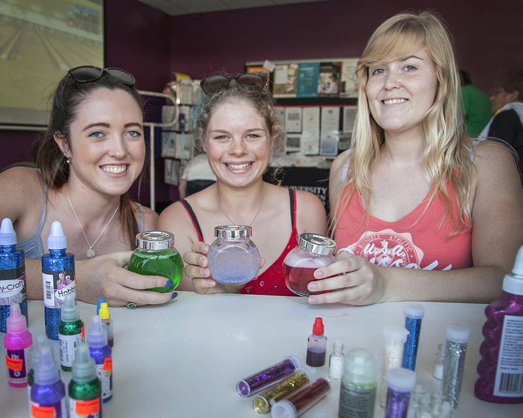 USQ students Grace Riley, Kate Law and Laura Archer make Calming Jars with water, food colouring and glitter to create a calming snow effect when the bottle is shaken at the university's health promotion fun day UFest. USQ students Grace Riley, Kate Law and Laura Archer make Calming Jars with water, food colouring and glitter to create a calming snow effect when the bottle is shaken at the university's health promotion fun day UFest.