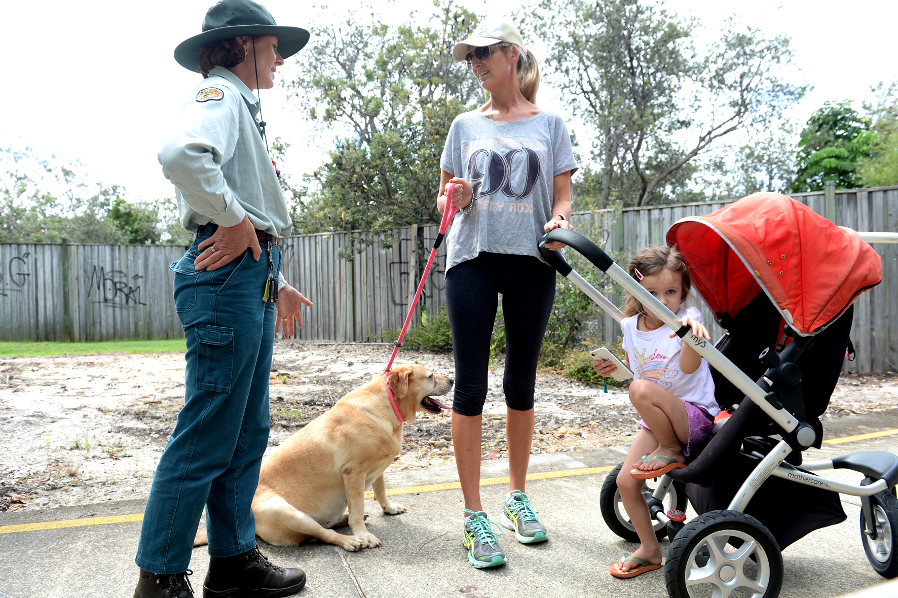IN DANGER: Kylie Kerr with her three-year-old Grace, are urged to leave a Casuarina cycleway by a National Parks and Wildlife Pest Management Officer Lisa Wellman on Monday afternoon. IN DANGER: Kylie Kerr with her three-year-old Grace, are urged to leave a Casuarina cycleway by a National Parks and Wildlife Pest Management Officer Lisa Wellman on Monday afternoon.