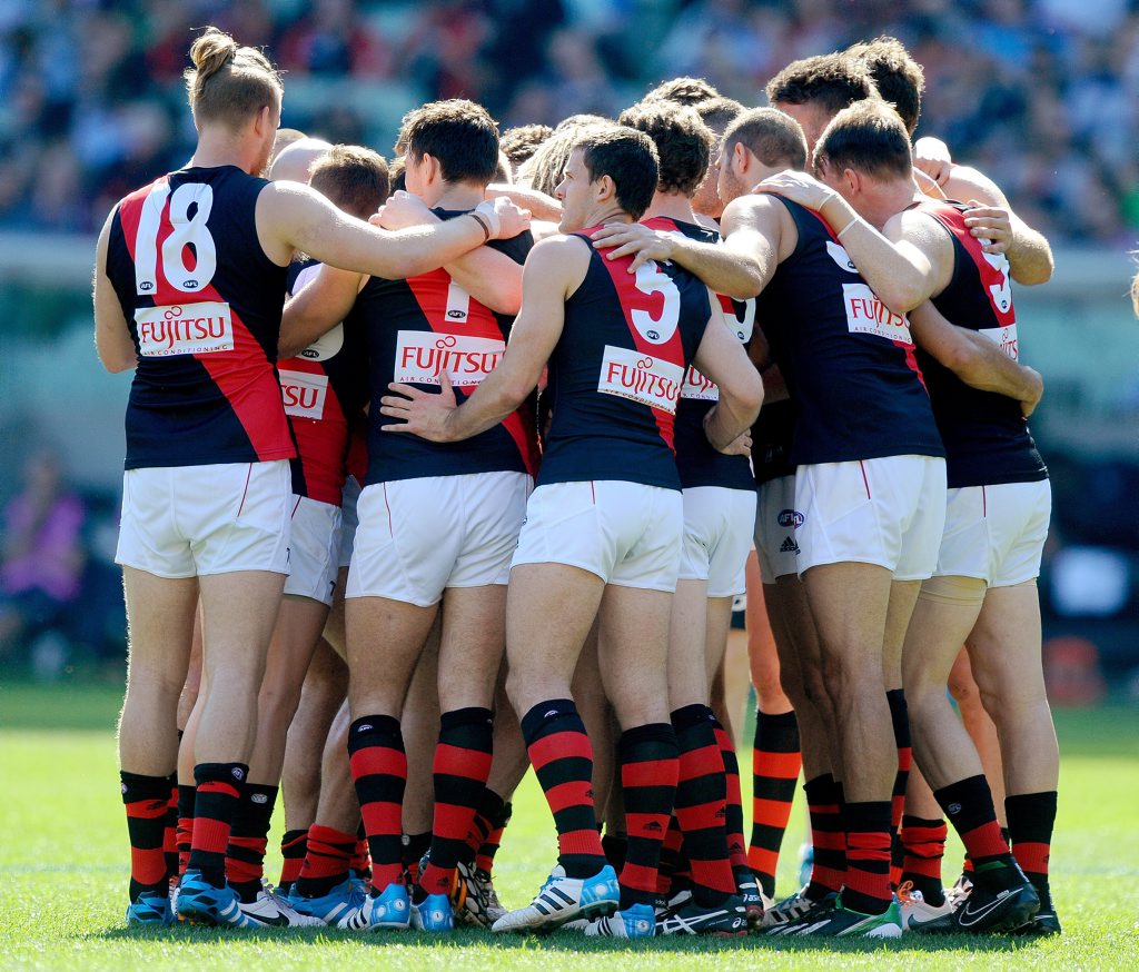 Essendon players get into a huddle before the start of the Round 23 AFL match between the Carlton Blues and Essendon Bombers at the MCG in Melbourne. Essendon players get into a huddle before the start of the Round 23 AFL match between the Carlton Blues and Essendon Bombers at the MCG in Melbourne.