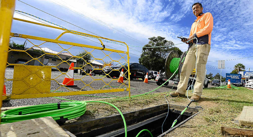 PLENTY OF WORK AHEAD: An NBN employee lays down fibre optic cable. PLENTY OF WORK AHEAD: An NBN employee lays down fibre optic cable.