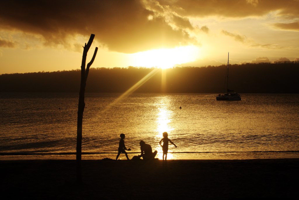 Image for sale: The sun glistens on the water as children play carelessly. Vanuatu aftermath from Cyclone Pam. Photo Vicki Wood / Caboolture News
