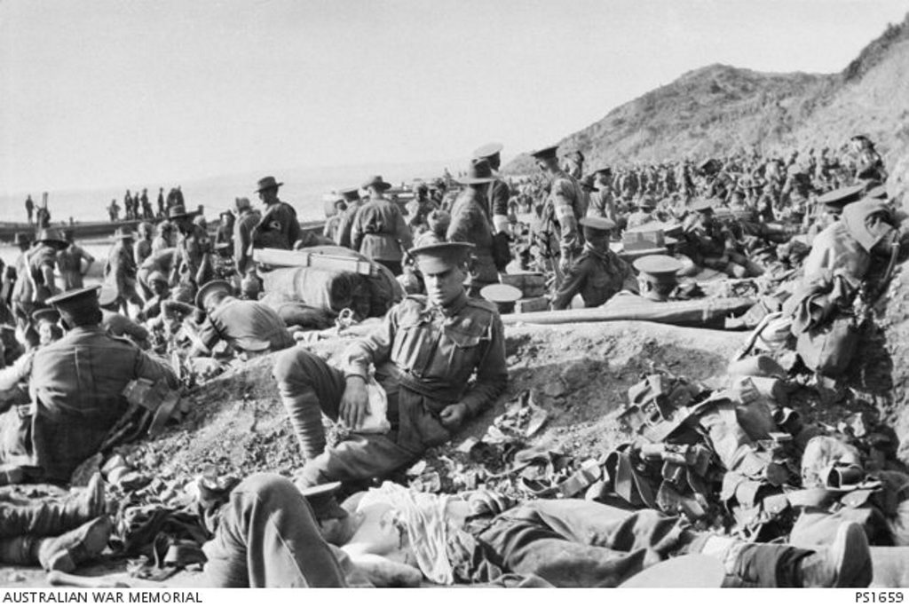 An Australian soldier lies wounded in the foreground, as hundreds of other soldiers move among the dead and wounded on the beach at Anzac Cove on the day of the landing. The soldiers wearing Red Cross arm bands are tending to the wounded. An Australian soldier lies wounded in the foreground, as hundreds of other soldiers move among the dead and wounded on the beach at Anzac Cove on the day of the landing. The soldiers wearing Red Cross arm bands are tending to the wounded.