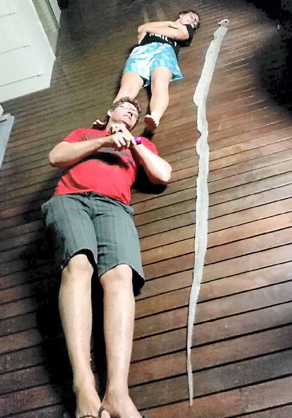 MONSTER: Wendy Roscoe shared this photo of her husband Chris and daughter Maddie lying next to a snake skin found at their Boyne Island home. MONSTER: Wendy Roscoe shared this photo of her husband Chris and daughter Maddie lying next to a snake skin found at their Boyne Island home.