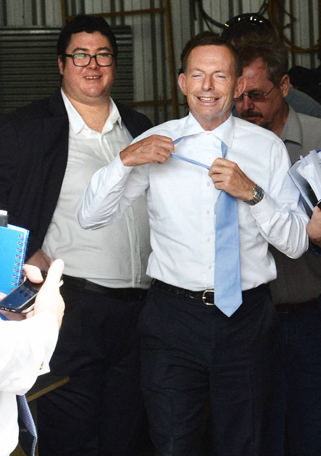 Prime Minister Tony Abbott’s tie comes off, standing next to George Christensen. Prime Minister Tony Abbott’s tie comes off, standing next to George Christensen.