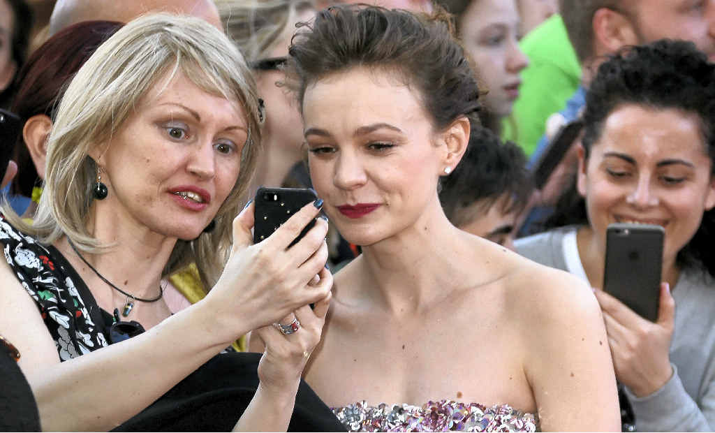 ABOVE LEFT: Carey Mulligan has a picture taken with a fan at the the world premiere of the film Far From The Madding Crowd in London. ABOVE RIGHT: Walking the Dorset countryside. ABOVE LEFT: Carey Mulligan has a picture taken with a fan at the the world premiere of the film Far From The Madding Crowd in London. ABOVE RIGHT: Walking the Dorset countryside.