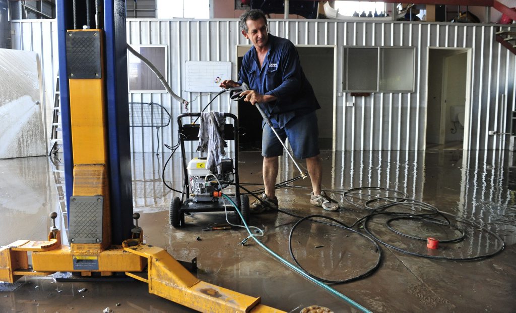 Gary Norman Duffy starts the clean up in his Keogh Street business after the 2013 flood. Photo: Rob Williams / The Queensland Times Gary Norman Duffy starts the clean up in his Keogh Street business after the 2013 flood. Photo: Rob Williams / The Queensland Times
