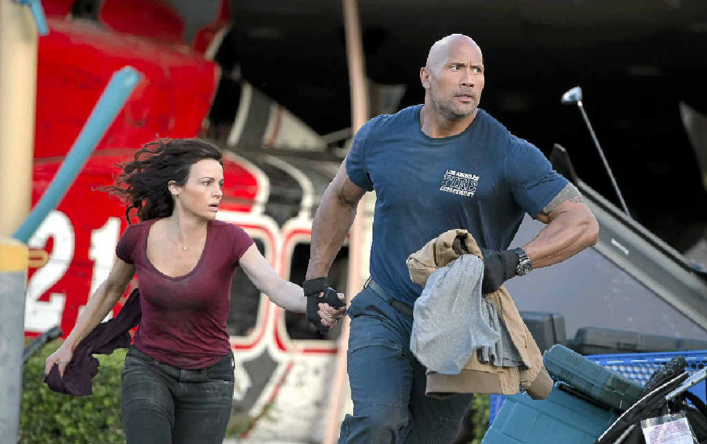 Carla Gugino and Dwayne Johnson in a scene from the movie San Andreas and (right) on set. Carla Gugino and Dwayne Johnson in a scene from the movie San Andreas and (right) on set.