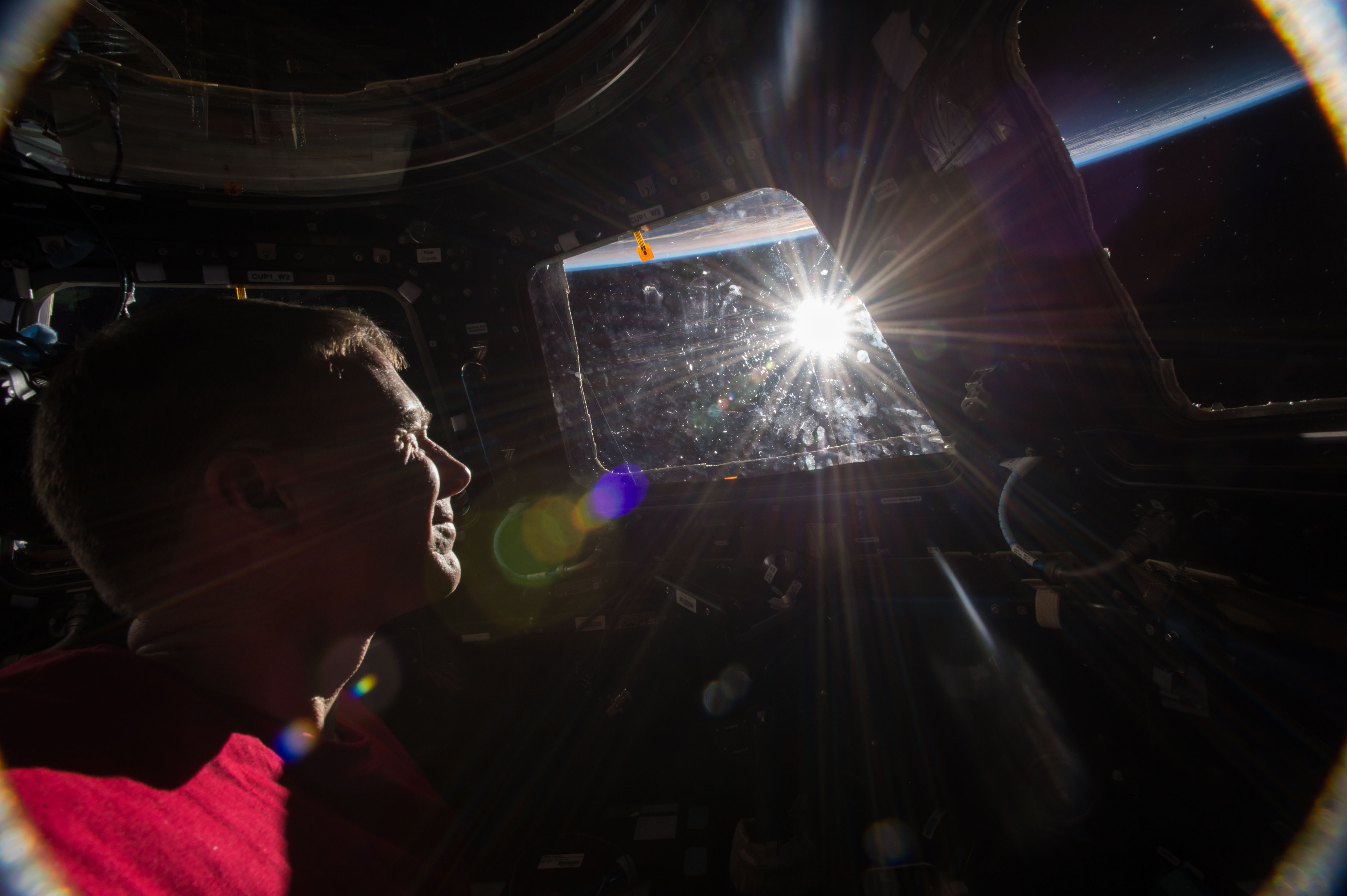 - NASA astronaut Terry Virts in the International Space Station on Earth sunrise Nov. 26, 2014 looks through the cupola window while checking the - NASA astronaut Terry Virts in the International Space Station on Earth sunrise Nov. 26, 2014 looks through the cupola window while checking the