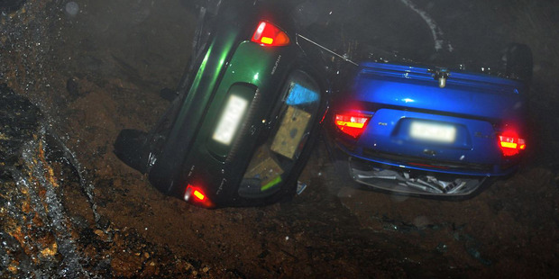 Two cars in a ditch after part of Highcliff Rd was swept away from in front of them last night. Two cars in a ditch after part of Highcliff Rd was swept away from in front of them last night.