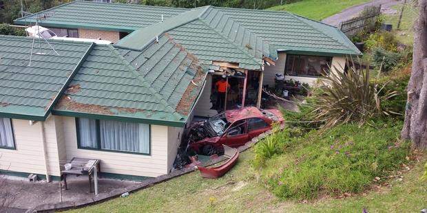 This car with five people in it took out a fence and a tree before crashing into a house below the road level. Photo: LINDY LAIRD This car with five people in it took out a fence and a tree before crashing into a house below the road level. Photo: LINDY LAIRD