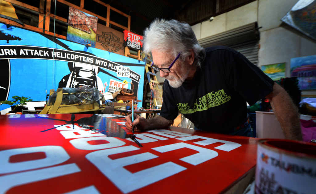PEACE MESSAGE: Peace activist Graeme Dunstan puts the finishing touches to the mural which will be mounted on the side of the Peacebus to be used in anti-Talisman Sabre protests.