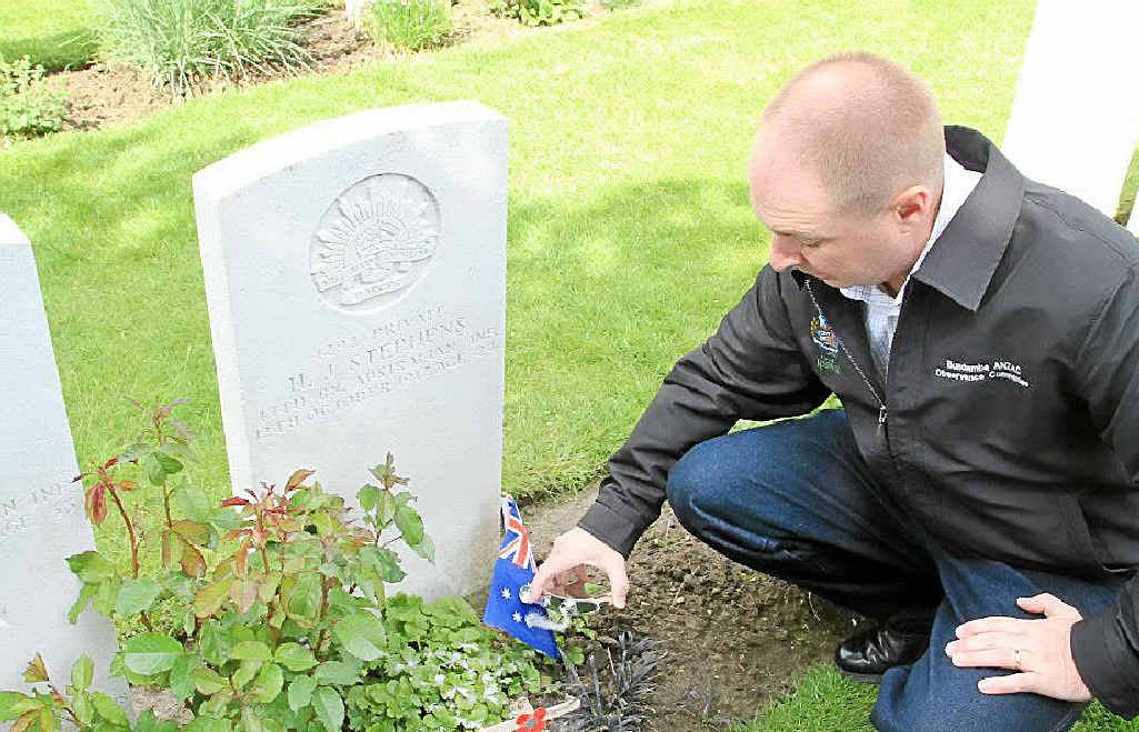 PAYING TRIBUTE: Brad Strong sprinkles soil from Bundamba Memorial Park on Ipswich soldier Private HJ Stephens’ grave at Tyne Cot Cemetery. PAYING TRIBUTE: Brad Strong sprinkles soil from Bundamba Memorial Park on Ipswich soldier Private HJ Stephens’ grave at Tyne Cot Cemetery.