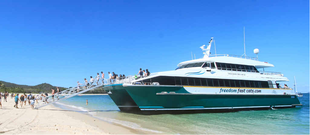 WELCOME TO PARADISE: The crowds disembark the Freedom Monarch on Fishermans Beach Great Keppel Island.