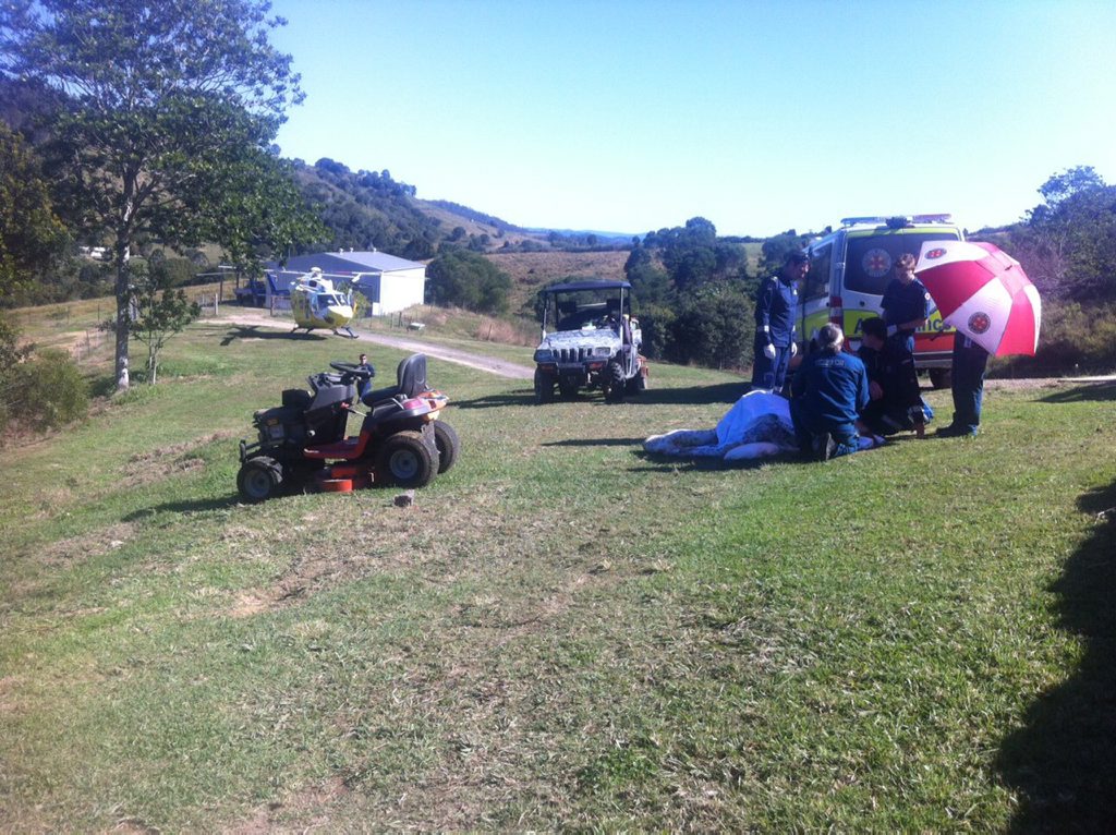 Paramedics and RACQ CareFlight helicopter medical staff help a woman who was injured in a ride-on lawn mower crash at a Federal property. Paramedics and RACQ CareFlight helicopter medical staff help a woman who was injured in a ride-on lawn mower crash at a Federal property.