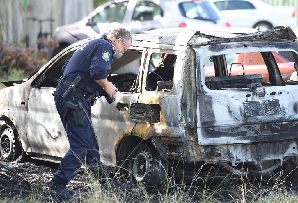 CRIME SCENE: A police officer takes photographic evidence of one of the burnt-out vehicles in Belongil Crescent in Byron Bay. CRIME SCENE: A police officer takes photographic evidence of one of the burnt-out vehicles in Belongil Crescent in Byron Bay.