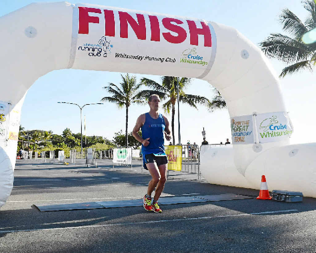 THE CHAMP: Airlie Beach Running Festival Half-Marathon winner Steve Jackson crosses the finish line on Sunday morning.