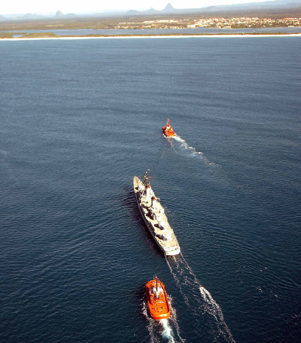 HMAS Brisbane is towed by tugboats past Caloundra in in preparation for being sunk. HMAS Brisbane is towed by tugboats past Caloundra in in preparation for being sunk.