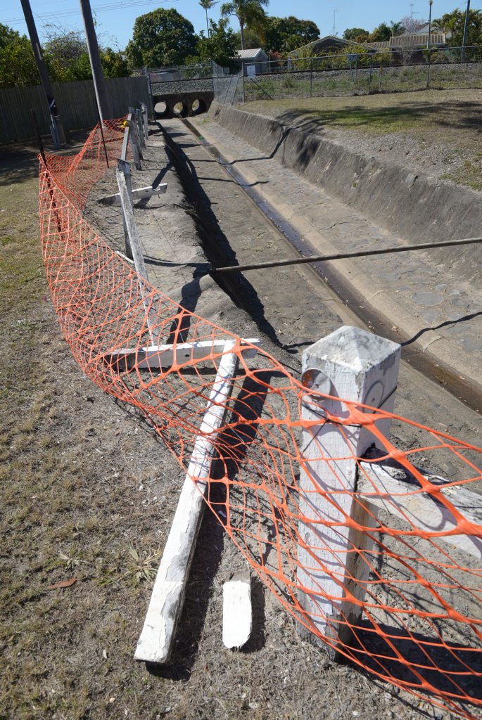 FEELING DRAINED: This drain on Edward Street drain has had the fencing half knocked down for about 12 months. Council workers have put up bright orange netting covering it. Photo: Max Fleet / NewsMail FEELING DRAINED: This drain on Edward Street drain has had the fencing half knocked down for about 12 months. Council workers have put up bright orange netting covering it. Photo: Max Fleet / NewsMail