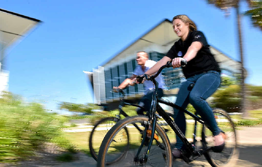 TAKING A SPIN: Youi employees (from left) Dion Locke and Mary Maclean use company bikes around the lake outside the Youi offices on Lake Kawana Boulevard. TAKING A SPIN: Youi employees (from left) Dion Locke and Mary Maclean use company bikes around the lake outside the Youi offices on Lake Kawana Boulevard.