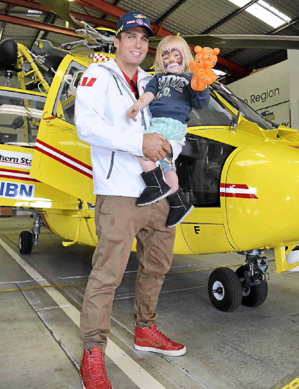 PROTECTION: Australian ironman and dual Olympian Ky Hurst, the Westpac Rescue Helicopter Schools Program ambassador, with son Koa, 2, at the service’s Open Day. PROTECTION: Australian ironman and dual Olympian Ky Hurst, the Westpac Rescue Helicopter Schools Program ambassador, with son Koa, 2, at the service’s Open Day.