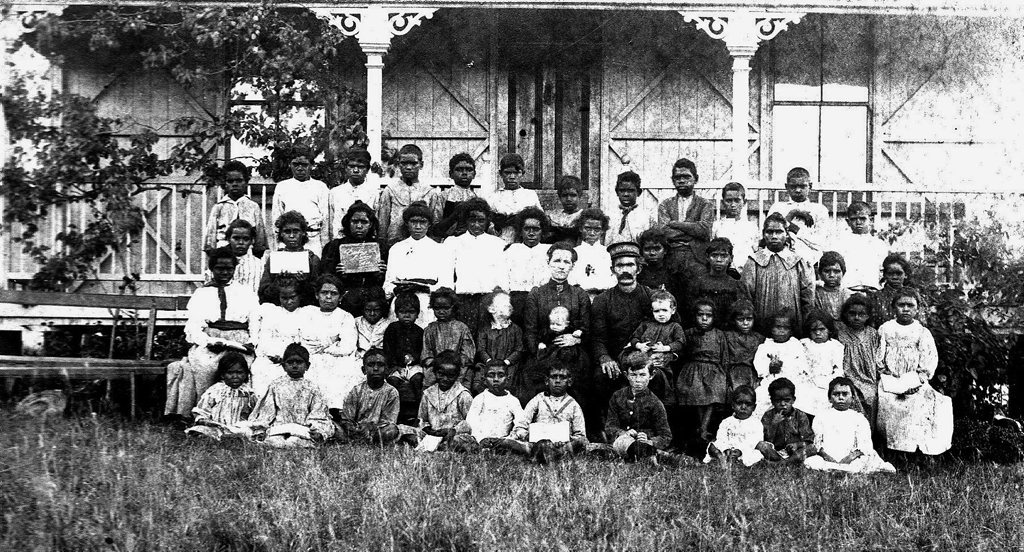 Thomas Ivins and Charlotte Ivins with a group of children at the mission.