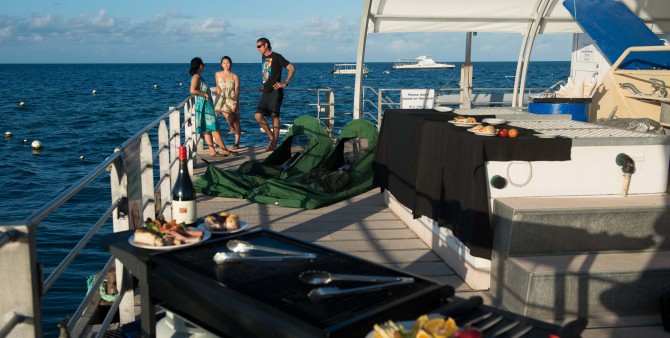 The crew hosts serve up a three-course gourmet barbecue dinner for guests spending the night at Moore Reef Pontoon on the Great Barrier Reef. The crew hosts serve up a three-course gourmet barbecue dinner for guests spending the night at Moore Reef Pontoon on the Great Barrier Reef.