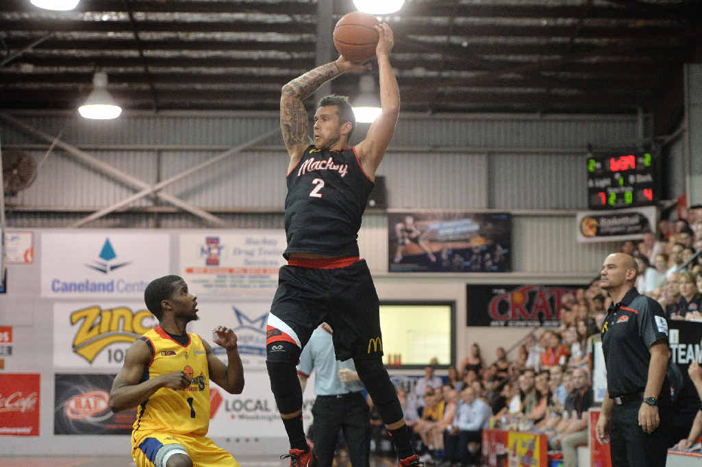 Mackay Meteors guard Tyson Demos goes aerial against the Brisbane Capitals in game two of the finals series with coach Joel Khalu (right) looking on. Mackay Meteors guard Tyson Demos goes aerial against the Brisbane Capitals in game two of the finals series with coach Joel Khalu (right) looking on.